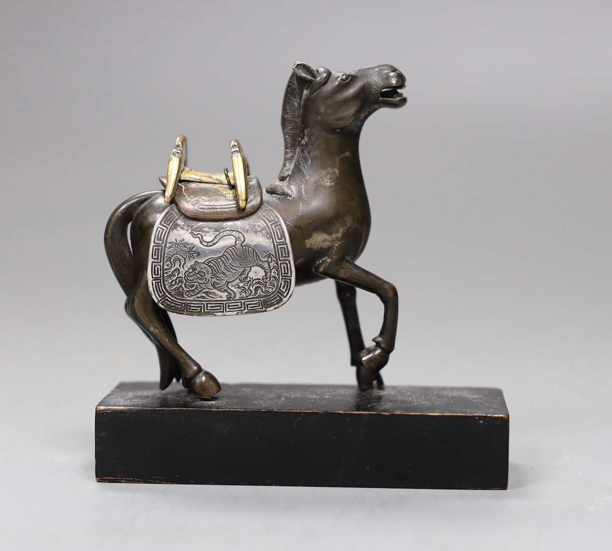 A Chinese bronze mixed metal figure a saddled horse, late 19th/early 20th century, wood stand, 8.5cms high